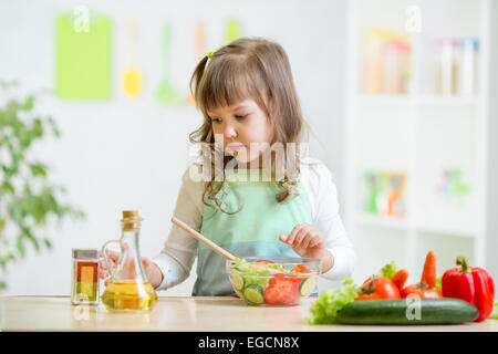 Kid girl comment préparer les légumes Banque D'Images