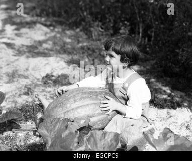 Années 1920 Années 1930 Petite fille assise tenant les grandes PUMPKIN Banque D'Images