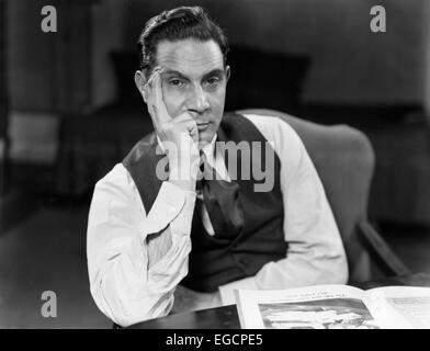 Années 1930 Années 1940 HOMME ASSIS COUDES SUR LA TABLE FACE À LA MAIN APPUYÉE SUR L'EXPRESSION GRAVE PORTANT SHIRTS VEST LOOKING AT CAMERA Banque D'Images