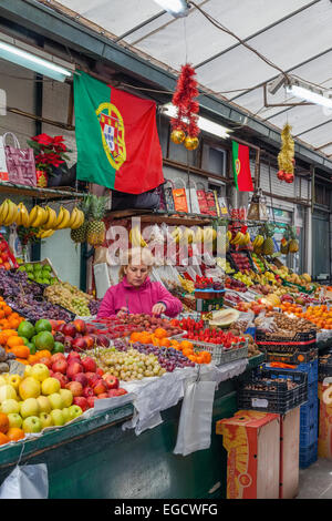 Porto, Portugal. Vendeur de fruits l'organisation et prendre soin de la parole à l'intérieur de l'historique marché Bolhão Banque D'Images