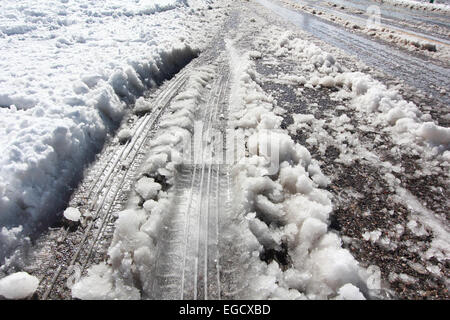 Les marques des traces de pneus sur la route de la couverture de neige en hiver Banque D'Images