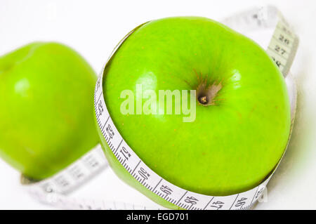 Pomme verte avec ruban à mesurer on white Banque D'Images