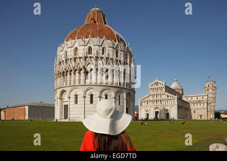 Woman admiring la Battistero, baptistère, Duomo, la cathédrale, le campanile, clocher, Torre Pendente, tour de Pise, la Piazza dei Miracoli (Place des Miracles, la Piazza del Duomo, la place de la cathédrale, l'UNESCO World Heritage Site, Pise, Toscane, Italie, Europe Banque D'Images
