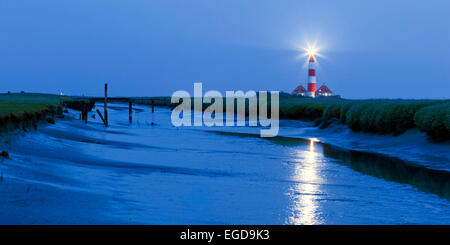 Panorama de la Lighthouse Westerheversand avec tide-way dans l'avant-plan au crépuscule, Schleswig-Holstein, Allemagne Banque D'Images