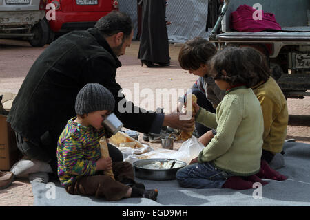 Damas. Feb 23, 2015. Photo prise le 23 février 2015 montre une famille syrienne déplacées dans une école qui a été transformé en un abri temporaire aux Syriens déplacés à Qudsaya quartier dans la campagne de Damas, en Syrie. Des centaines de familles syriennes ont récemment été évacués de la ville de Douma tenues par les rebelles. © Bassem Tellawi/Xinhua/Alamy Live News Banque D'Images