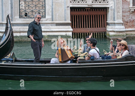 La chanteuse d'opéra mâle divertit sur la famille godola passe Rio de Palazzo de Canonica Venise Italie près de Pont des Soupirs Banque D'Images