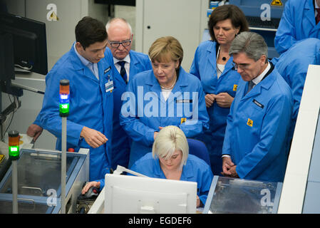 Amberg, Allemagne. Feb 23, 2015. La chancelière Angela Merkel (C)se tient derrière un employé à côté de Siemens Chef Joe Kaeser (R), directeur d'usine Karl-Heinz Buettner (2.E.L), et le ministre bavarois de l'économie à l'Ilse Aigner Siemens electronics factory (EWA) à Amberg, Allemagne, 23 février 2015. La chancelière Merkel a reçu des informations à propos de la numérisation de l'industrie au cours de sa visite en Bavière. L'usine est considéré comme le premier exemple de l'usine Siemens 'Digital' domaine d'affaires. Dpa : Crédit photo alliance/Alamy Live News Banque D'Images