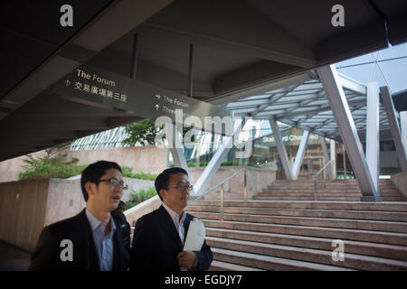 Deux hommes d'affaires d'agréables promenades le long de Exchange Square dans le centre de Hong Kong tôt le matin en allant au travail. Banque D'Images