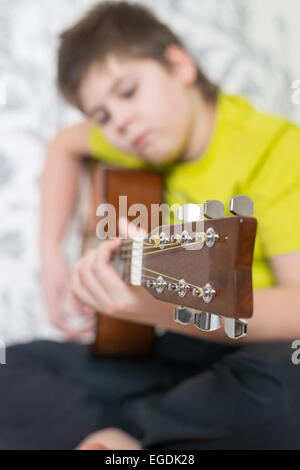 Teenage Boy joue une guitare acoustique Banque D'Images