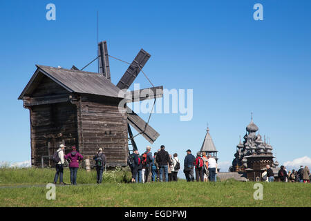 Les gens en face de moulin à vent en bois, le beffroi et l'église de l'Intercession de la Vierge et l'église de la Transfiguration à Kizhi Pogost à distance, l'île de Kizhi, le lac Onega, la Russie, l'Europe Banque D'Images