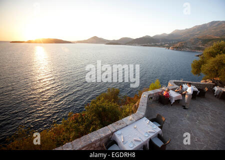 Couple en train de dîner sur la terrasse d'un restaurant, vue sur la baie de Budva, Aman Sveti Stefan, Sveti Stefan, Budva, Monténégro Banque D'Images