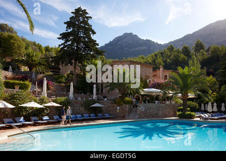 Couple en train de marcher le long d'une piscine de l'hôtel, Serra de Tramuntana en arrière-plan, Deia, Majorque, Espagne Banque D'Images
