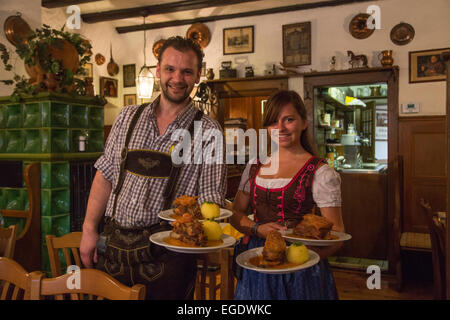 Serveur et serveuse sympa les assiettes de service avec des boulettes de porc, en Schaeufele Herrenkeller restaurant de Boehm, Nuremberg, Franconia, Bavaria, Germany Banque D'Images