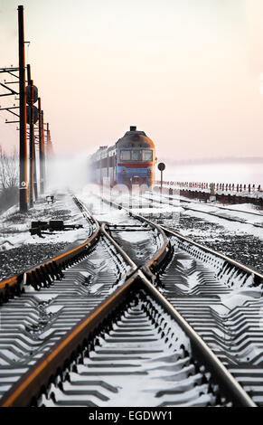 Train de voyageurs rapidement le long du couloir de neige Banque D'Images