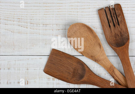 High angle shot de 3 ustensiles de cuisine en bois dans le coin inférieur droit du cadre. La cuillère, fourchette, spatule et ont leur Banque D'Images