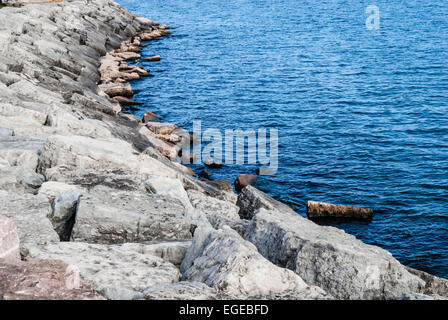 Mur de pierre en pente par Blue Water. Banque D'Images