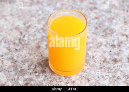 Verre de jus d'orange placé sur une table en marbre. Banque D'Images