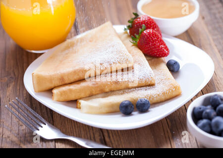 Délicieux crêpes roulées sur une assiette de fruits frais Banque D'Images