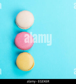 Colorés et savoureux Macarons français sur fond bleu.vue d'en haut. Banque D'Images