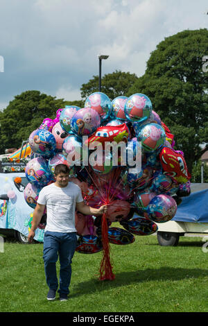 Man carrying large bouquet de ballons à air libre Journée carnaval à Chesterfield Derbyshire, Angleterre Banque D'Images