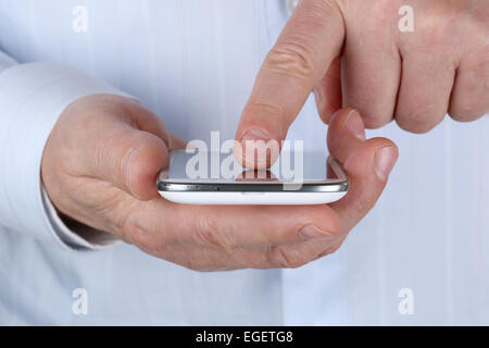 Un senior businessman en utilisant un smartphone en basculant avec ses doigts Banque D'Images