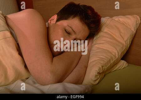 Une femme se trouve dans son lit et dort. Un sommeil sain est essentiel pour le bien-être d'une personne. Prise le 03/11/2014 à Iserlohn. Banque D'Images