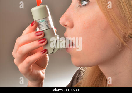 Le symbole 'Photo' montre une jeune femme pendant l'inhalation d'un aérosol asthme |. Banque D'Images