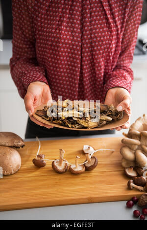 Gros plan sur les jeunes housewife montrant des champignons séchés Banque D'Images