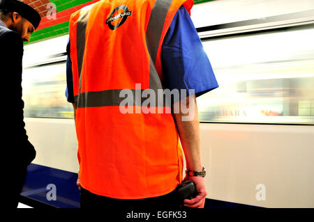 Londres, Angleterre, Royaume-Uni. La station de métro de Londres / employé et de passagers sur la plate-forme Banque D'Images