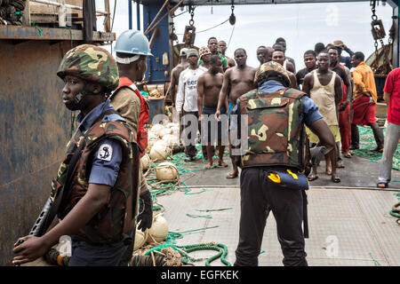 Les marins de la Marine ghanéenne watch l'équipage d'un navire de pêche au cours d'une visite, un conseil, vous pouvez, et la saisie d'un navire de pêche avec les états de la Marine américaine dans le cadre de l'Afrique de l'application de la Loi maritime le 19 février 2015 Partenariat, au large des côtes du Ghana. Banque D'Images