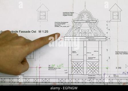 Lemgo, Allemagne. Feb 24, 2015. Un employé de la Kramp & Kramp atelier de menuiserie points à partie des plans pour la "Goldene Waage' à Lemgo, Allemagne, 24 février 2015. Les spécialistes de Lemgo sont la reconstruction la boiserie du 'Goldene Waage, ' l'une des plus magnifiques maisons dans le quartier de la vieille ville de Francfort. Les maisons, détruit dans la deuxième guerre mondiale, sont d'être reconstruit et reconstruit en partie en conformité avec les structures d'origine. Photo : OLIVER KRATO/dpa/Alamy Live News Banque D'Images