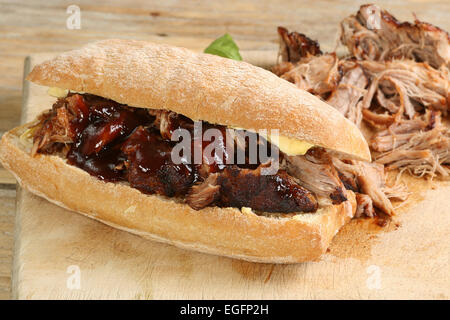 Avec un barbecue de porc sauce sur un pain croustillant roll Banque D'Images