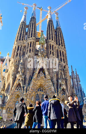 Groupe de touristes dans un front de Sagrada Familia conçue par Antoni Gaudi. Barcelone, Catalogne, Espagne. Banque D'Images