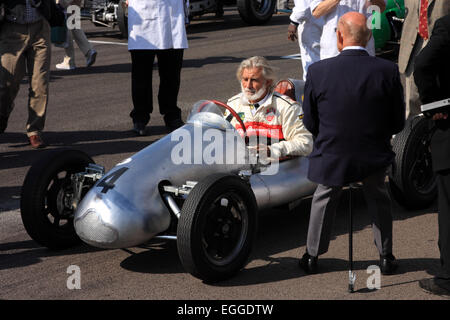 Stirling Moss (dos à la caméra) s'appuie sur son bâton de tir sur la grille de départ pour la Parade des Légendes / Goodwood Revival / UK Banque D'Images