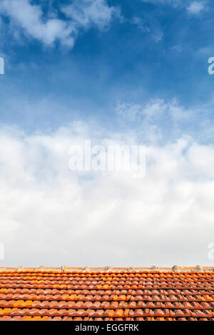 Arrière-plan photo vide avec toit en tuiles rouges et bleu ciel nuageux Banque D'Images