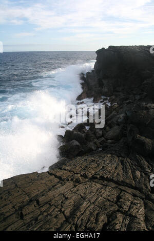Les coulées de lave du volcan Kilauea refroidie et couverts et désormais interagir avec les vagues se briser en provenance de l'océan Pacifique à Hawaï Banque D'Images