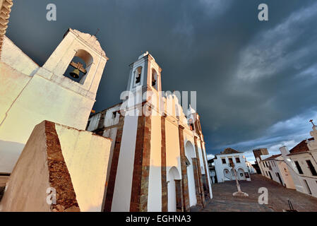 Le Portugal, l'Alentejo : ciel dramatique au-dessus de blanc, de l'église paroissiale et les bâtiments du village historique de Monsaraz Banque D'Images