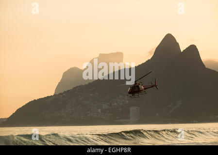 Hélicoptère de sauvetage volant au-dessus de la plage d'Ipanema au coucher du soleil, Rio de Janeiro, Brésil, Amérique du Sud Banque D'Images