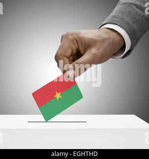 Mâle noir tenant un drapeau. Concept de vote - Burkina Faso Banque D'Images