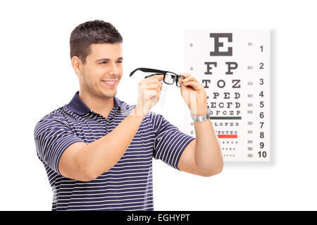 L'essuyant ses lunettes l'homme en face d'un tableau isolé sur fond blanc Banque D'Images