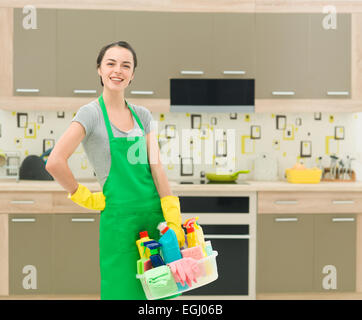 Les jeunes professionnels caucasian female standing in kitchen holding Produits ménagers Banque D'Images