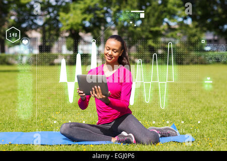 Smiling woman with tablet pc outdoors Banque D'Images