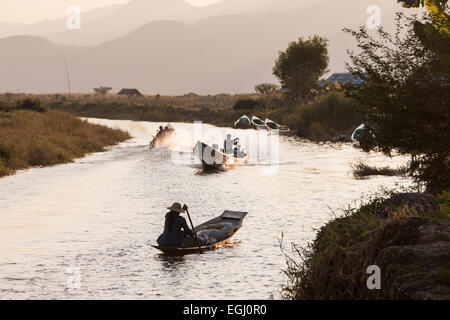 Bateau de vitesse,longboat,bateau à moteur à longue queue sur les voies navigables canal près de ville Nyaungshwe sur les banques du lac Inle (Birmanie, Myanmar,.Coucher du soleil. Banque D'Images