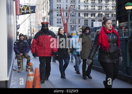 Les piétons à pied le long du bas du Broadway dans de forts vents et des températures de gel dans la ville de New York. Banque D'Images