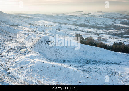 L'après-midi douce lumière sur un paysage enneigé ci-dessous Coombes edge au-dessus du village de Charlesworth, Derbyshire. Banque D'Images