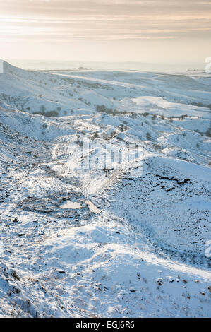 L'après-midi douce lumière sur un paysage enneigé ci-dessous Coombes edge au-dessus du village de Charlesworth, Derbyshire. Banque D'Images