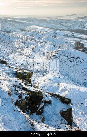 L'après-midi douce lumière sur un paysage enneigé ci-dessous Coombes edge au-dessus du village de Charlesworth, Derbyshire. Banque D'Images