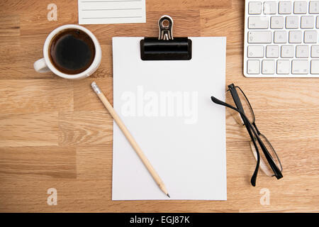 Le papier blanc, le café, les verres et le clavier sur la table office Banque D'Images