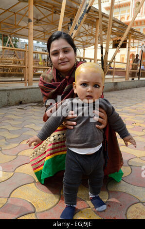 Un Indien baby boy avec sa mère après son Mundan ou tête de Ram Raja Temple cérémonie Orchha Madhya Pradesh, Inde Banque D'Images