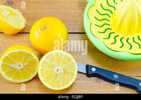 Ensemble, coupés en deux et citrons pressés et un presse-citron sur une table de bambou Banque D'Images